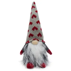 Detailed macro view of a Christmas gnome doll featuring a heart-patterned grey knitted hat.
