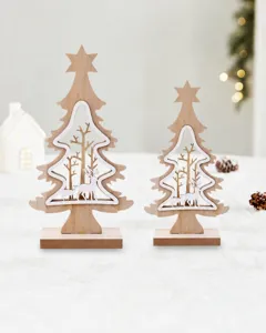 Detail of two wooden Christmas tree ornaments with reindeer forest cutouts on snow.