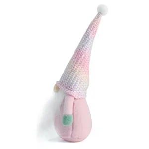 Gedetailleerd zijaanzicht van een roze pluchen kerstkabouter met een gebreide muts