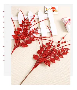 Gros plan de deux tiges artificielles à paillettes rouges pour décoration de Noël