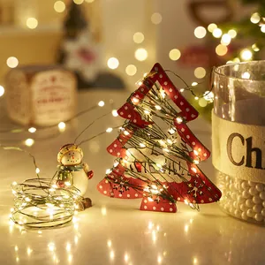 Warm white LED fairy lights string wrapped around a red wooden Christmas tree ornament