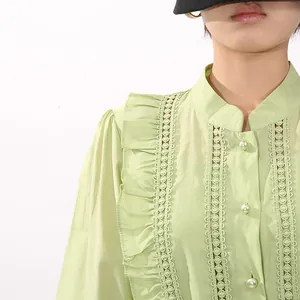 Detail eines salbeigrünen Kleides mit Spitzenrüschen und eleganten Perlenknöpfen