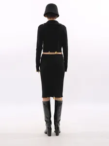 Elegant black two-piece knit set with cropped top and skirt featuring gold charms
