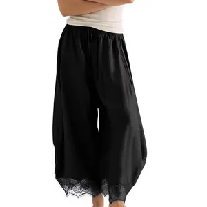 Détail du pantalon incurvé noir pour femme avec taille élastique et ourlet en dentelle.