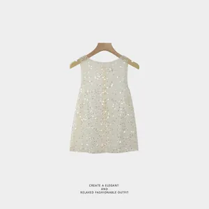 Elegant sleeveless top with shimmering silver sequins presented on a wooden hanger