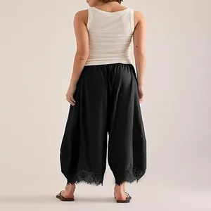 Vue arrière d'un pantalon noir à jambes incurvées avec bordure en dentelle à l'ourlet