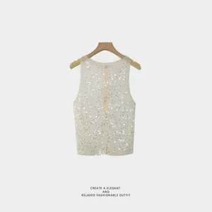 Detailed view of women's white sequined sleeveless vest with back zipper design.