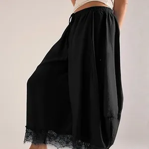Vue détaillée du pantalon noir avec une élégante bordure en dentelle à l'ourlet