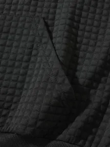 Makrodetail aus schwarzem Waffelstrick mit Taschennaht und geripptem Saumabschluss