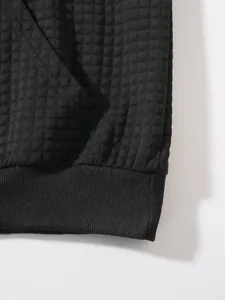Detailaufnahme der schwarzen Waffelstrick-Struktur und des Rippbündchens an diesem Herren-Sweatshirt