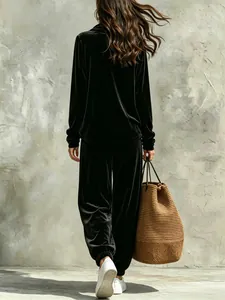 Rear view of women's black velvet lounge set with long sleeves and jogger pants.