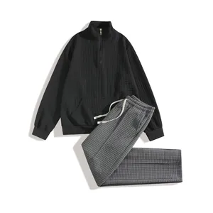 Detailed view of men's waffle knit sweatshirt and matching pants set in black and grey textures.