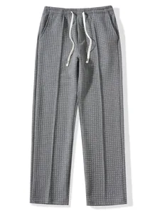 Close-up of grey waffle knit trousers with white drawstring and elastic waistband