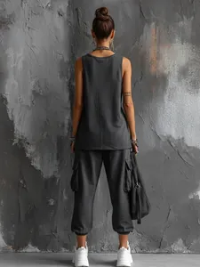 Back view of a woman wearing a charcoal grey sleeveless tank top and cargo sweatpants.