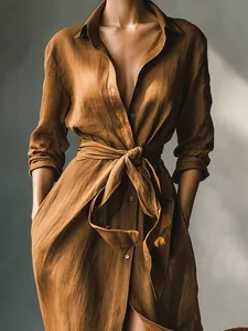Detailed view of an elegant brown long-sleeved shirt dress with a stylish waist tie detail.