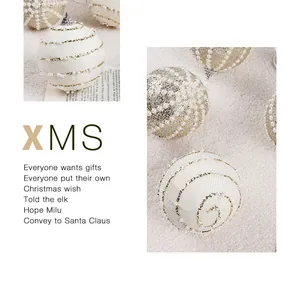 Detalle de bolas de Navidad de espuma blanca con cadenas de perlas y purpurina dorada