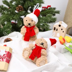 Deux adorables ours en peluche de Noël avec bonnets et écharpes rouges en décor festif.