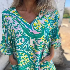 Détail d'une robe d'été à col en V avec un imprimé paisley abstrait vert et rose