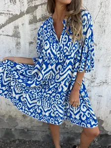 Detailed view of the vibrant blue and white ikat print on a V-neck tiered mini dress