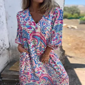 Vue détaillée de l'imprimé abstrait coloré sur une robe d'été à col en V avec poches.