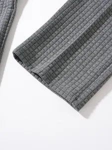 Close-up detail of grey waffle knit fabric texture on men's casual joggers or sweatshirt