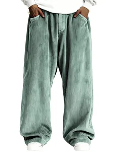 Gros plan de la texture velours côtelé vert sauge d'un pantalon rétro homme.