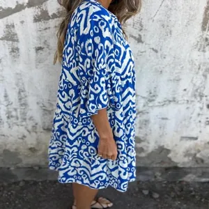 Side view of a casual blue and white printed summer mini dress with ruffled sleeves