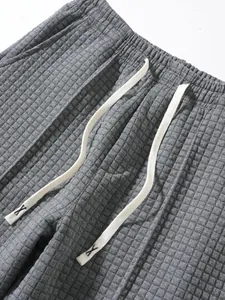Detailed view of grey waffle knit texture and elastic waistband with cream drawstring