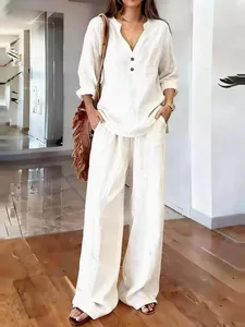Elegant white cotton linen set featuring a V-neck long sleeve top and wide-leg trousers.