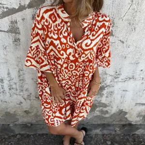 Detail view of women's orange abstract print V-neck pleated mini dress for summer