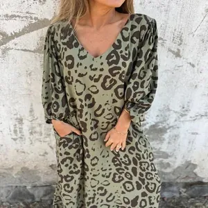 Détail d'une robe longue imprimé léopard avec col en V, manches longues et poches.
