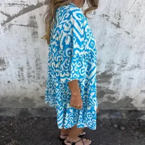 Side view of a casual blue and white printed V-neck pleated dress for summer fashion.