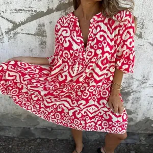 Detailed view of bohemian V-neck printed mini dress featuring a vibrant pink pattern