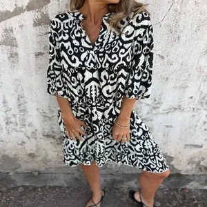 Close-up of a casual V-neck dress featuring a black and white abstract geometric print.