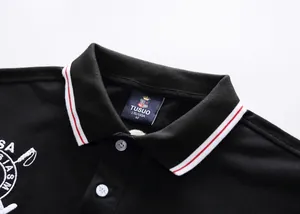 Detail shot of black cotton Polo shirt with red and white striped collar and TUSUO label