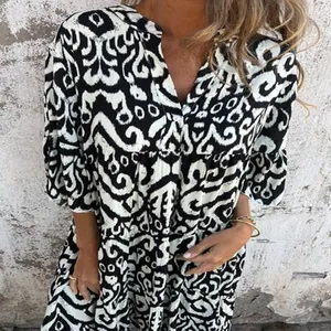 Detail view of a stylish black and white printed V-neck dress with elegant pleated sleeves
