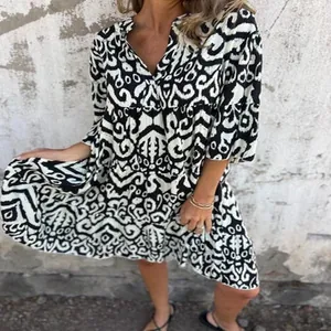 Close-up detail of a casual V-neck printed pleated dress featuring a black and white pattern