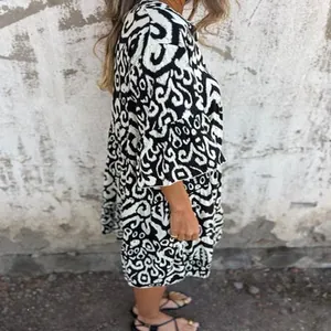 Side view detail of a casual V-neck dress with black and white abstract tribal prints