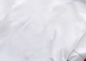 Macro close-up detail showing the breathable pique fabric texture of a white men's polo shirt