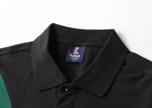 Close-up of black and green color-block Polo shirt collar with brand neck label details