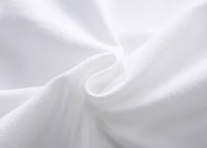 Macro close-up of white cotton piqué fabric texture for breathable mens polo shirt