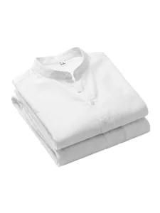 Close-up of neatly folded white linen Henley shirts showing collar and fabric texture.