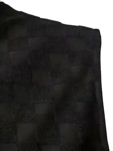Gros plan sur le tissu jacquard à damier noir avec des carrés en tissu éponge texturé