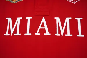 Μακροεντολή λευκού κεντήματος γραμμάτων MIAMI σε κόκκινο βαμβακερό ύφασμα ανδρικού μπλουζάκι πόλο