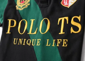 Close-up of embroidered 'POLO TS' logo on diagonal striped men's polo shirt
