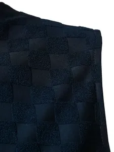 Gros plan du tissu jacquard à damier bleu marine avec texture éponge pour gilet homme.
