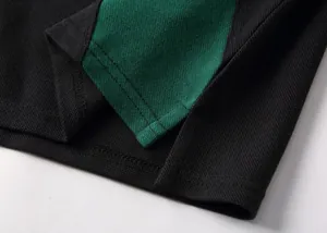 Macro detail of the side vent and reinforced stitching on a cotton pique polo shirt.