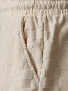 Close-up showing the premium cream checkerboard jacquard texture on men's casual shorts