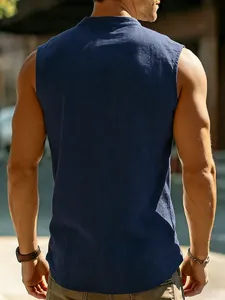 Back view of a men's navy blue linen sleeveless Henley shirt in sunny outdoor setting.