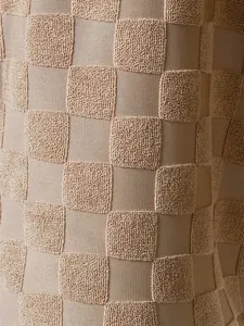 Vue macro de la texture détaillée du tissu jacquard à carreaux du débardeur beige
